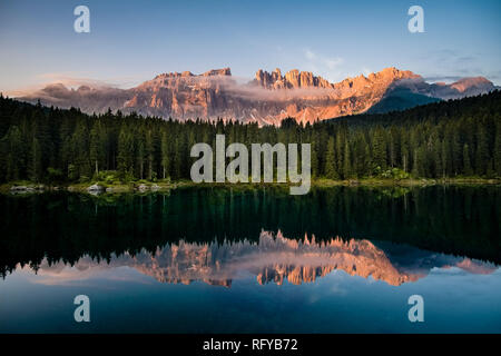 Panoramablick auf die Berge Latemar, Spiegelung in der Karersee, Lago di Carezza bei Sonnenaufgang Stockfoto