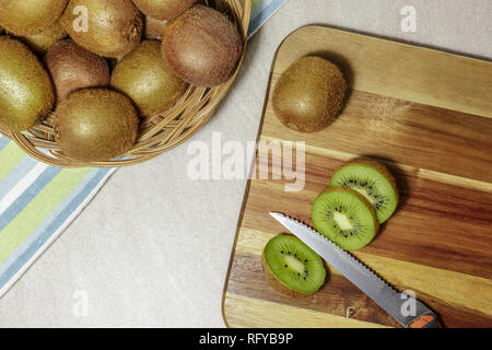 Reif ganzen Kiwis und Scheiben auf einem Schneidebrett mit einem alten Messer, bereitet detox Smoothie. Stockfoto