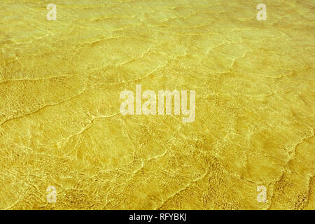 Leere abstrakt Hintergrund natürlich von kleinen Wellen des Meeres im flachen Wasser und Sonnenlicht Reflexionen auf Wasser Fläche erzeugt. Farben in den Farben Golden Stockfoto