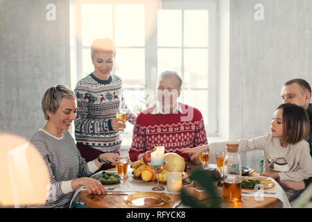 Positive Familie hat am Tisch am Wochenende versammelt Stockfoto