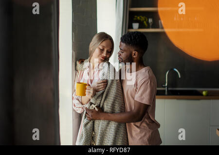 Liebende schwarze afrikanische jungen Mann umarmt seine kaukasische Frau. Stockfoto