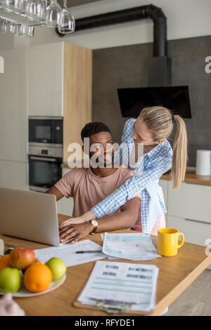 Junge interracial Paare mit Laptop zusammen frühstücken zu Hause Stockfoto