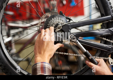 Punkt der Hände der männlichen Mechaniker im Fahrrad Werkstatt, Reparatur Fahrrad mit Spezialwerkzeug Stockfoto