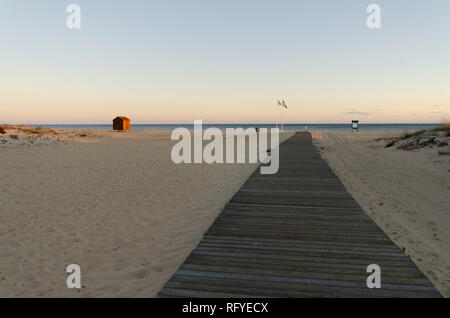 Strand bei Sonnenuntergang mit Holzsteg führt zu Kabine, Hütte, Praia da Manta Rota, Algarve, Portugal, Europa. Stockfoto