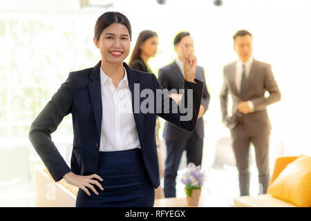 Portrait von asiatischen Geschäftsfrau mit Business Team im Hintergrund bei Office Fenster mit für Coporate arbeiten Hintergrund Stockfoto