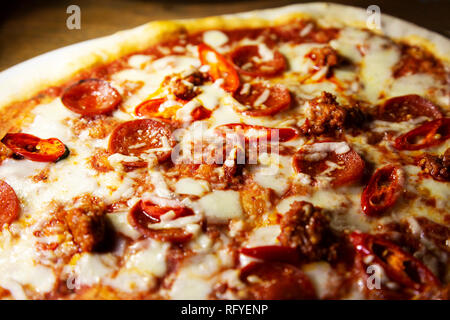 Stein - gebackene gekrönt mit Salami, Wurst Fleisch und Chilis. Stockfoto