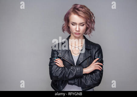 Portrait von unglücklichen traurig schöne Mädchen mit kurzen Frisur und Make-up im lässigen Stil schwarze Lederjacke ständigen geschlossenen Augen mit crosed Arme. ind Stockfoto