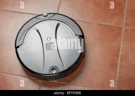 Roboter Staubsauger arbeiten auf Fliesenboden. smart-Technologie. Stockfoto