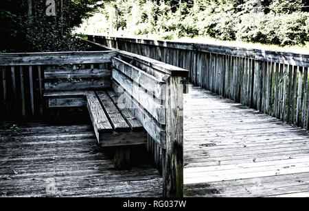 Holz- dunkelgrau Parkbank isoliert auf der Brücke in der Nähe von Fußweg Stockfoto