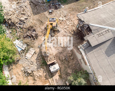 Luftaufnahme von Industriemaschinen auf abbruchbaustelle in Müll und Ruinen arbeiten Stockfoto