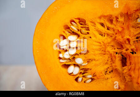 Lecker und gesund und fleischigen Gemüse - saftig, hell orange Kürbis in einem Schnitt mit Samen. Kürbis Oval geformte harte Kruste. Stockfoto