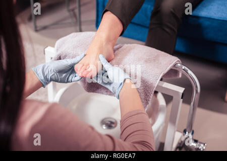 Schöne junge Frau mit einer Fußmassage Stockfoto
