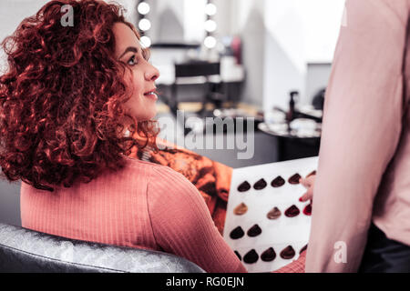 Schöne rothaarige Frau hören auf Ihr Friseur Stockfoto