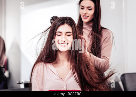 Gute Freuen suchen junge Frau, die ihre Augen schließen Stockfoto