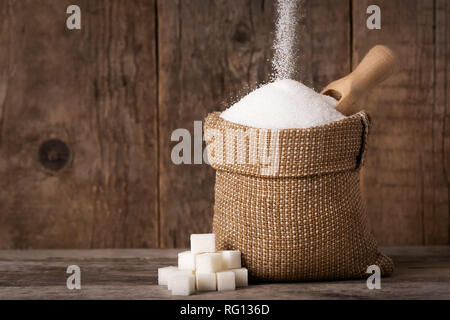 Zucker in den Sack fallen auf Holz- Hintergrund Stockfoto