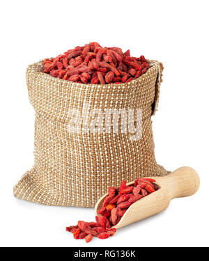 Getrocknete Goji Beeren in Sack und hölzerne Schaufel auf weißem Hintergrund Stockfoto