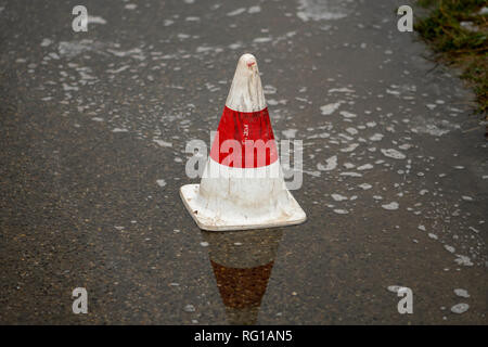 Pilone auf der Straße in eine Pfütze von Regen Stockfoto