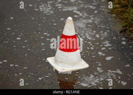 Pilone auf der Straße in eine Pfütze von Regen Stockfoto