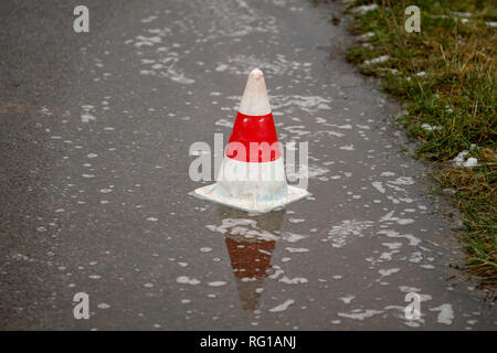 Warnung Hütte auf der Straße in einem regen Pfütze Stockfoto