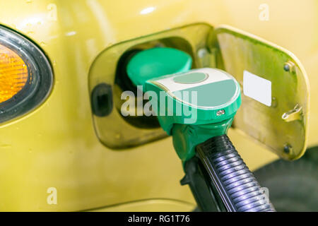 Gelb, Gold Auto an einer Tankstelle mit Kraftstoff gefüllt werden Stockfoto