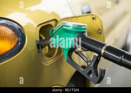 Gelb, Gold Auto an einer Tankstelle mit Kraftstoff gefüllt werden Stockfoto