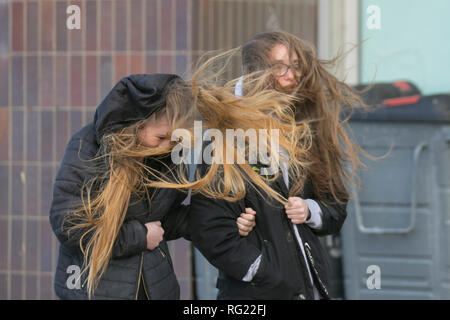 Blackpool, Lancashire. 27 Jan, 2019. UK Wetter. Gale force Winde an der Küste. Die Besucher der Stadt am Meer haben strenge Winde mit Fußgängern auf der Strandpromenade ausgeblasen wird zu ertragen. Sturm, Schlag, tempest, Flyaway Haar, verwirrte Tresses, Bad Hair Day auf der Strandpromenade. Credit: MediaWorldImages/AlamyLiveNews Stockfoto