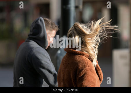 Blackpool, Lancashire. 27 Jan, 2019. UK Wetter. Gale force Winde an der Küste. Die Besucher der Stadt am Meer haben strenge Winde mit Fußgängern auf der Strandpromenade ausgeblasen wird zu ertragen. Sturm, Schlag, tempest, Flyaway Haar, verwirrte Tresses, Bad Hair Day auf der Strandpromenade. Credit: MediaWorldImages/AlamyLiveNews Stockfoto