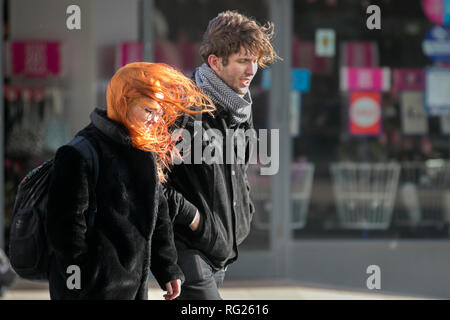 Blackpool, Lancashire. 27 Jan, 2019. UK Wetter. Gale force Winde an der Küste. Die Besucher der Stadt am Meer haben strenge Winde mit Fußgängern auf der Strandpromenade ausgeblasen wird zu ertragen. Sturm, Schlag, tempest, Flyaway Haar, verwirrte Tresses, Bad Hair Day auf der Strandpromenade. Credit: MediaWorldImages/AlamyLiveNews Stockfoto