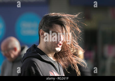 Blackpool, Lancashire. 27 Jan, 2019. UK Wetter. Gale force Winde an der Küste. Die Besucher der Stadt am Meer haben strenge Winde mit Fußgängern auf der Strandpromenade ausgeblasen wird zu ertragen. Sturm, Schlag, tempest, Flyaway Haar, verwirrte Tresses, Bad Hair Day auf der Strandpromenade. Credit: MediaWorldImages/AlamyLiveNews Stockfoto