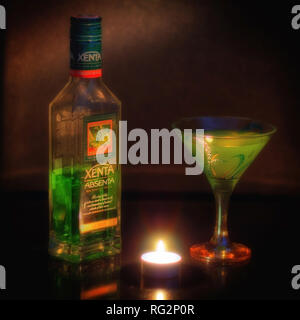 Still-Leben mit einer Flasche Absinth, ein Glas und eine Kerze auf dem Tisch. Stockfoto