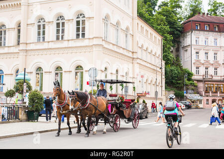 Karlsbad, TSCHECHISCHE REPUBLIK - 13. JUNI 2017: eine Pferdekutsche erwartet Touristen am Ufer des Flusses Tepla. Stockfoto