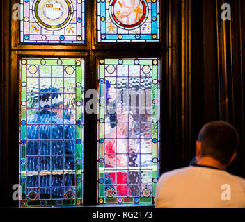 Person, die durch die Buntglasfenster, verzerrten Sicht der Passanten durch das Fenster gesehen, Hull, East Yorkshire, England, Großbritannien Stockfoto