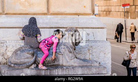 Junge Mädchen und Frau sitzt auf der Statue von Lion, Palermo, Sizilien, Italien, Europa Stockfoto