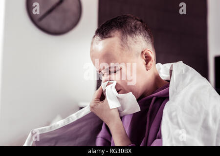 Düstere kranken Mädchen bläst Nase in Serviette Stockfoto
