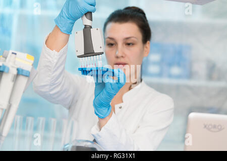 Junge Frau mit der genetischen Forschung im Labor Forschung von Krebserkrankungen Stockfoto