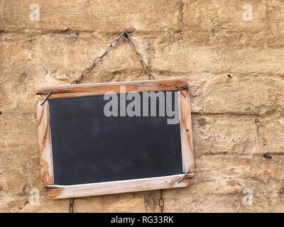 Tafel mit Holzrahmen auf alte Mauer. Stockfoto
