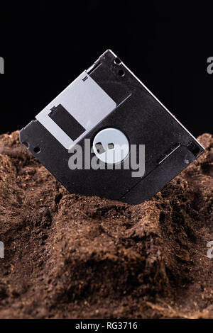 Die Diskette ist halb in die Erde eingegraben. Stockfoto