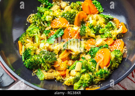 Vegan Wok braten mit Broccoli und Karotten verrühren, dunkle backgrond. Stockfoto