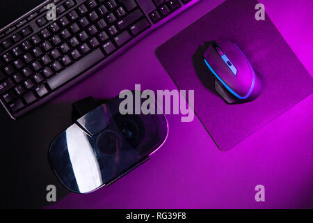 Ansicht von oben ein Gaming Gear, Maus, Tastatur, Joystick, Headset, VR-Headset auf Schwarz tisch Hintergrund. Gamer Arbeitsbereich Konzept. Stockfoto