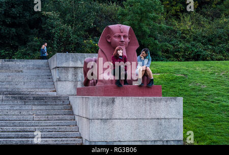 Zwei Frauen sitzen auf lackierten Terrakotta Sphinx, Teil des Grand Terrasse, Crystal Palace, London, England, Großbritannien Stockfoto