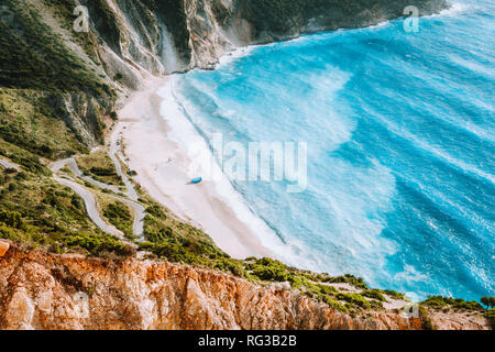 Erstaunlich Myrtos Beach mit rollenden Wellen. Wunderschöne Küste, Felsen am Meer Bucht, umgeben von blauem Wasser, Kefalonia, Ionische Inseln, Griechenland Stockfoto