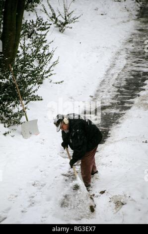 DEU, Deutschland: Ein Mann ist die Reinigung der Bürgersteige von Schnee. Stockfoto