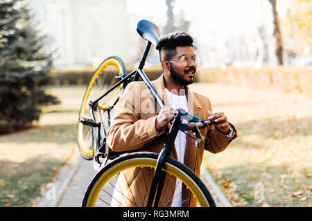 Bärtige inder Fahrrad auf der Schulter in der Stadt Stockfoto