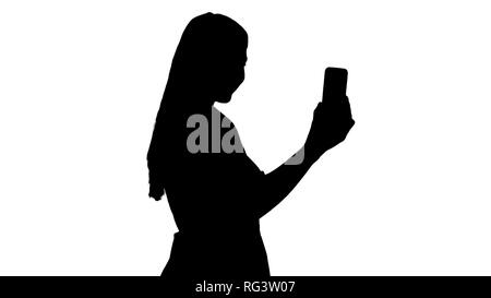 Mittellange Aufnahme von der Seite. Silhouette Frau im rosa Kleid, mit Ihrem Smart Phone. Professionelle Aufnahme in 4K-Auflösung. 005. Sie können es verwenden, Stockfoto