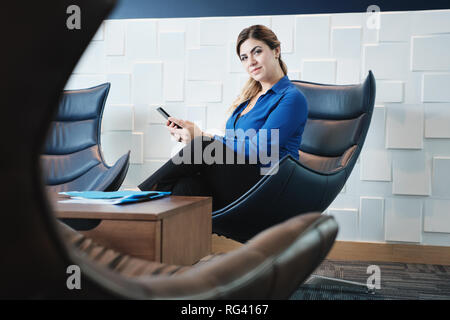 Portrait ernsthaften Geschäftsfrau auf Kamera im Büro Wartezimmer Stockfoto