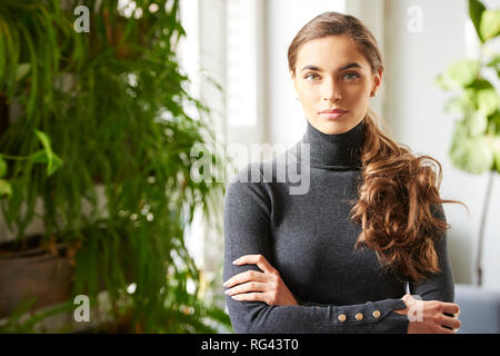 Nahaufnahme Porträt der schönen jungen Frau mit Rollkragen Pullover bei Kamera suchen und lächelnd Indoor. Stockfoto