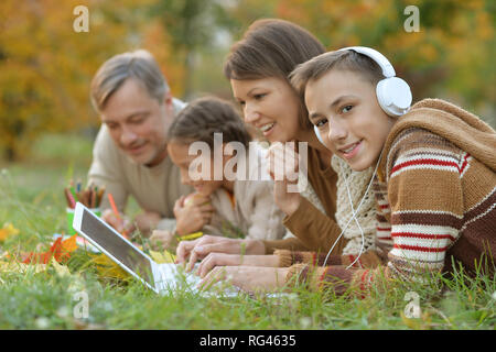 Portrait von Vater, Mutter und Kinder Hausaufgaben in Park Stockfoto