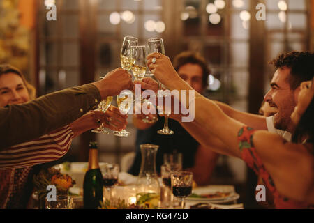 Gruppe von Menschen toasten Getränke an einer Partei. Junge Freunde Drinks einen besonderen Anlass zu feiern. Stockfoto