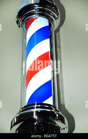 Gestreift blau rot Friseur pole Close-up auf grauem Hintergrund. Stockfoto