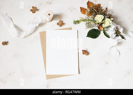 Feminine winter Hochzeit, Geburtstag Schreibwaren Mock-up-Szene. Leere Grußkarte, Umschlag. Trockene Hortensie, weiße Rosen und gypsophila Blumen Blumenstrauß. Stockfoto